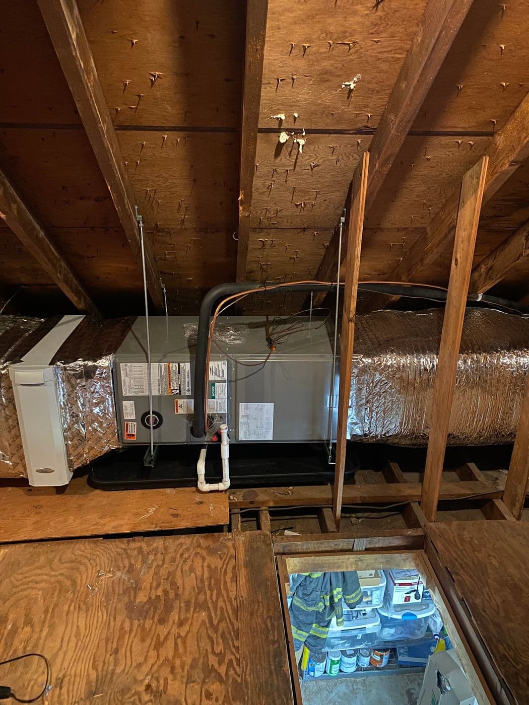 Relocated air handler with newly built ductwork in an attic