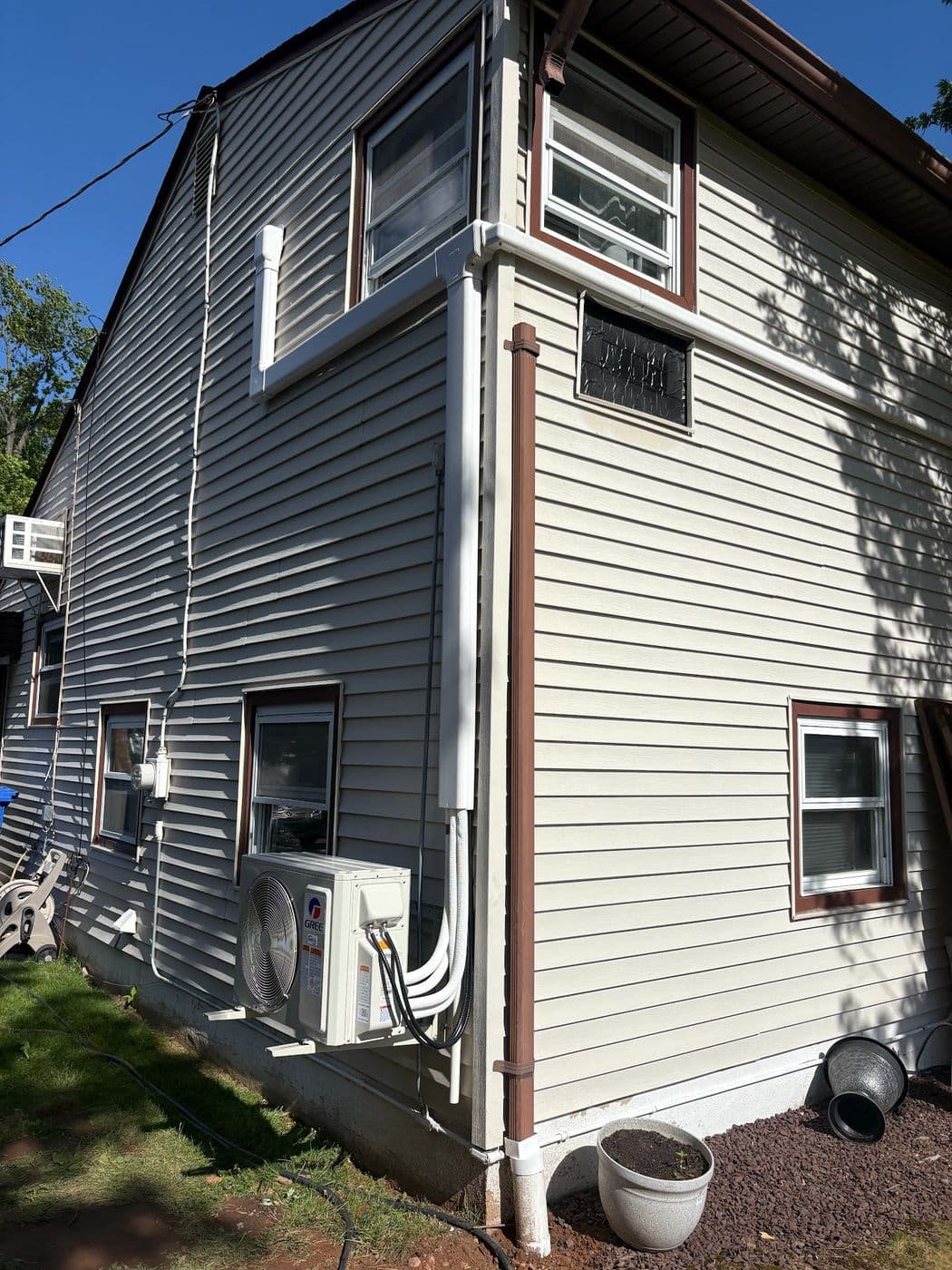 Two condensers mounted on the side of a home for a six zone ductless system