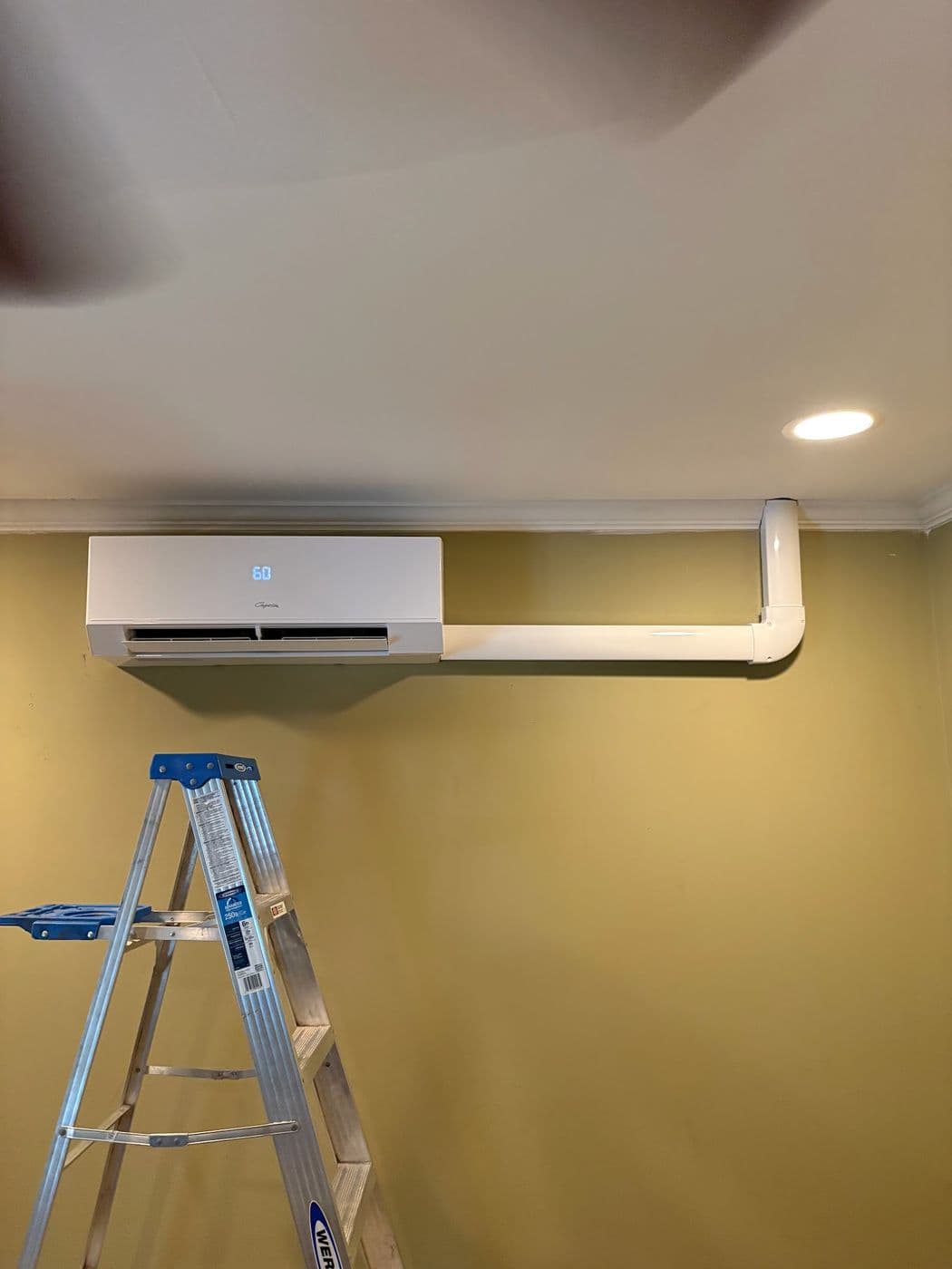 The same room with a ductless mini split head fitted above the wall